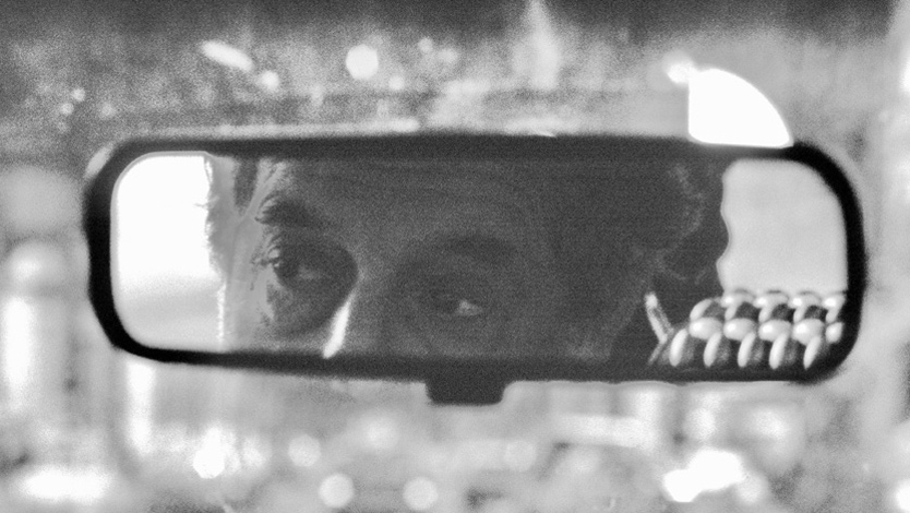 A man’s eyes in a rear-view mirror